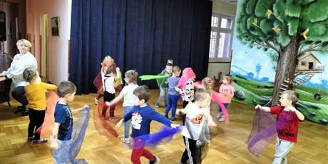 dzieci tańczą z chustkami na zajęciach rytmicznych