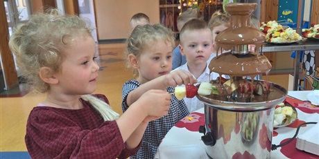 dzieci moczą szaszłyki owocowe w czekoladzie