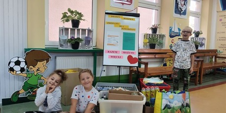 dzieci sa usmiechniete przy darach dla powodzian